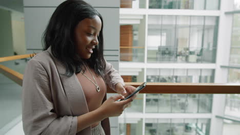 African-American-Woman-Typing-on-Smartphone-in-Business-Center